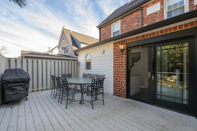 deck with outdoor dining area and grilling area