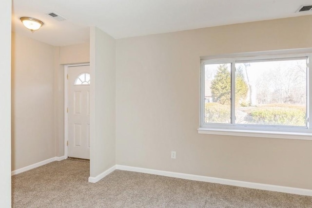 unfurnished room featuring baseboards, carpet flooring, visible vents, and a healthy amount of sunlight