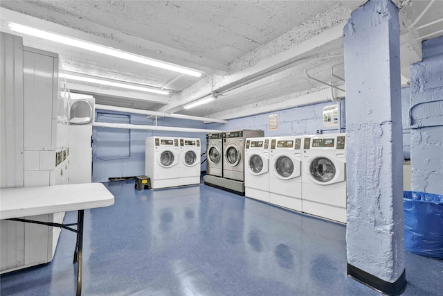 community laundry room featuring a garage, separate washer and dryer, and stacked washer / drying machine