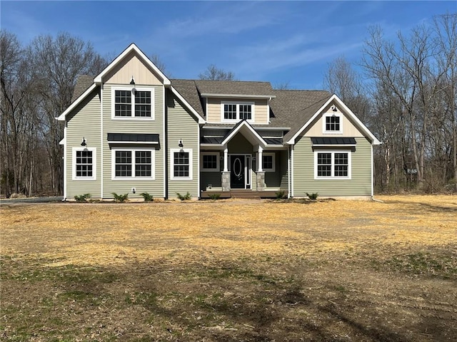 view of front of home with a standing seam roof, metal roof, and roof with shingles