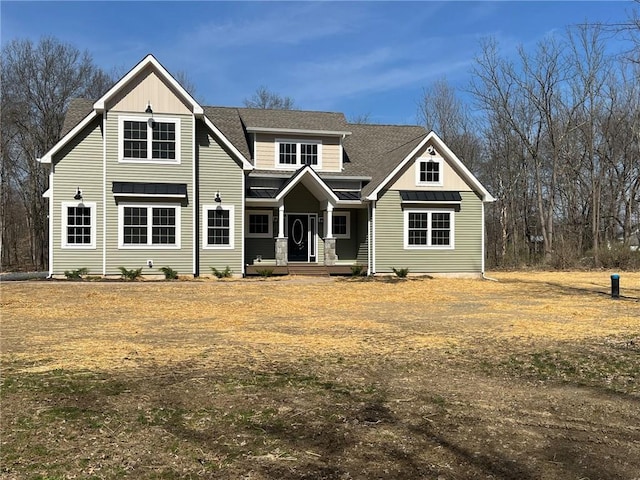 view of front facade with a shingled roof, a standing seam roof, and metal roof