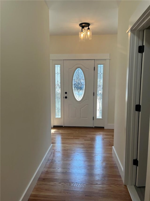 foyer with baseboards and wood finished floors