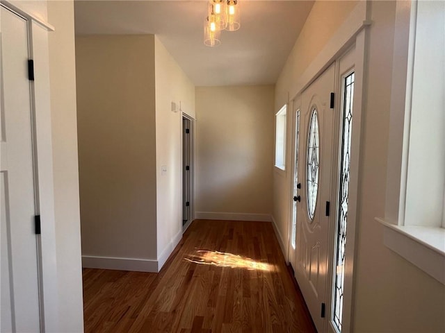 foyer entrance with wood finished floors and baseboards