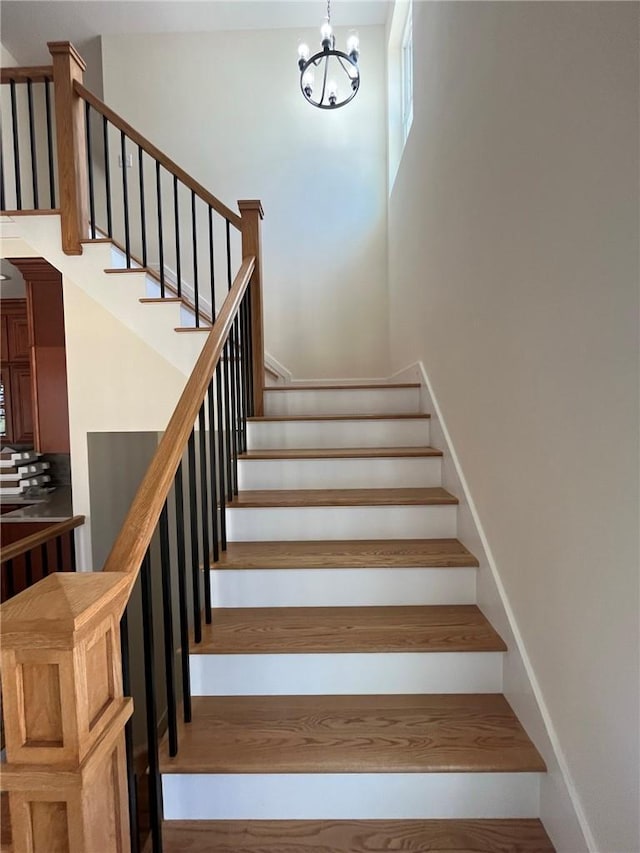 stairway with a chandelier and a high ceiling