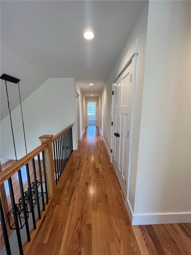 corridor featuring baseboards and wood finished floors