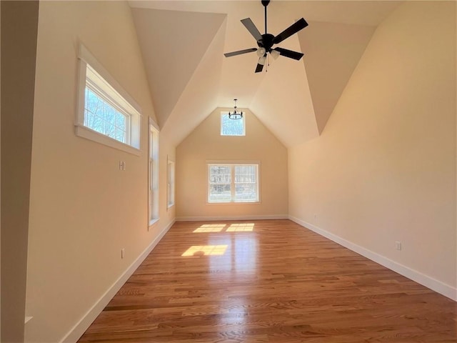 bonus room with a wealth of natural light, baseboards, lofted ceiling, and light wood finished floors