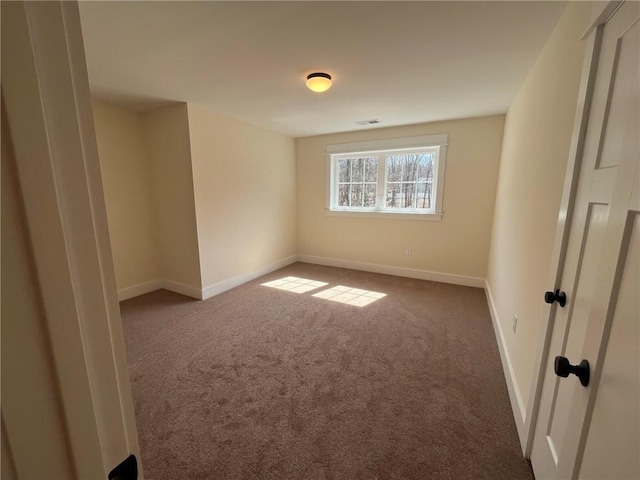 unfurnished room with carpet flooring, visible vents, and baseboards