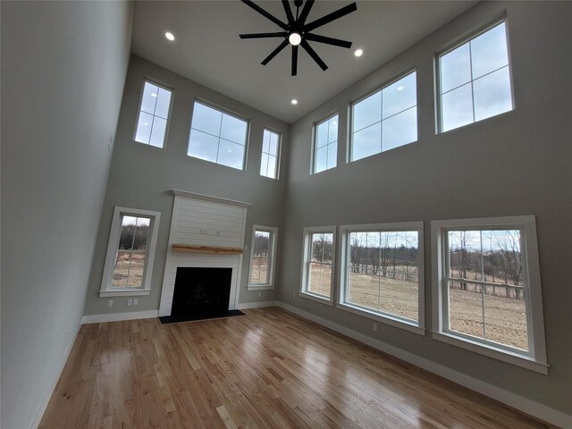 472 Wheeler Rd, Florida, NY 10921 - unfurnished living room featuring baseboards, a high ceiling, a ceiling fan, and wood finished floors