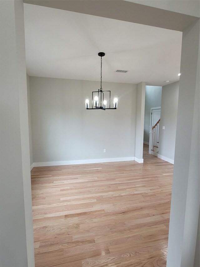 472 Wheeler Rd, Florida, NY 10921 - spare room featuring light wood-style floors, visible vents, baseboards, an inviting chandelier, and stairs