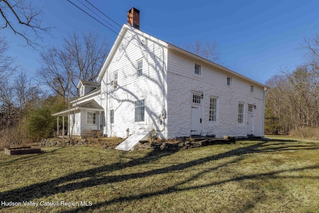 view of home's exterior featuring a lawn and a chimney