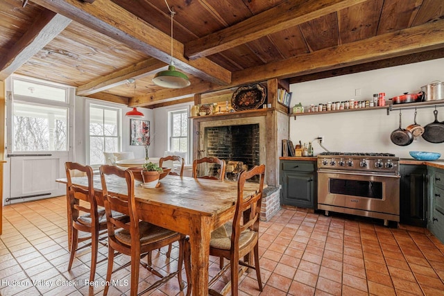 dining room featuring light tile patterned floors, beamed ceiling, and wooden ceiling