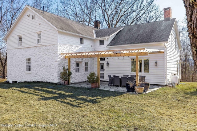 rear view of property with a yard, a patio area, a pergola, and a chimney