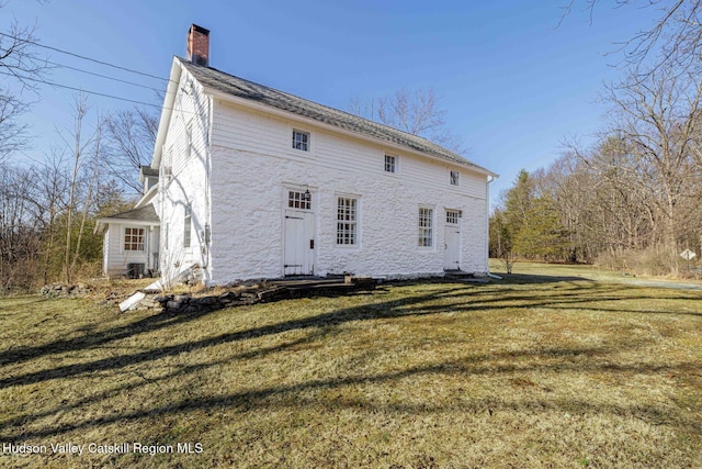 rear view of house with a lawn and a chimney