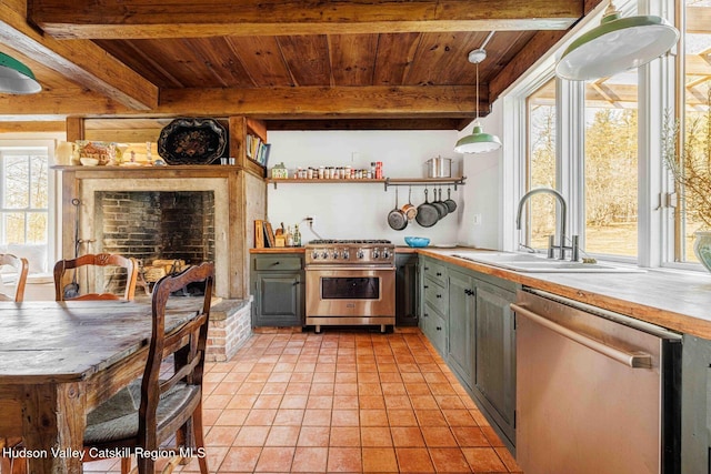 kitchen with beamed ceiling, a sink, stainless steel appliances, wooden ceiling, and light countertops