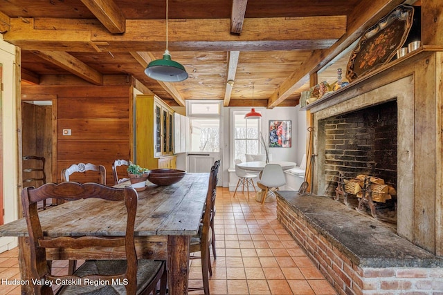 dining area with light tile patterned floors, beamed ceiling, and wood ceiling