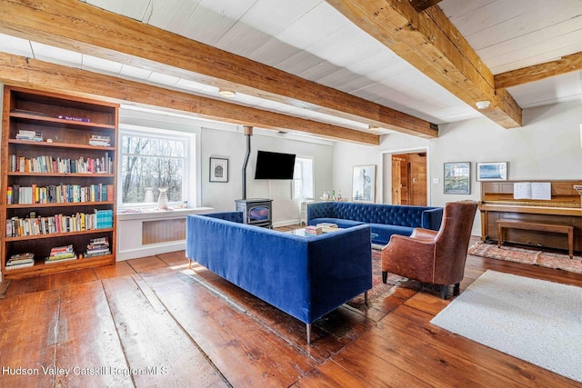 living area with a wealth of natural light, hardwood / wood-style floors, and a wood stove