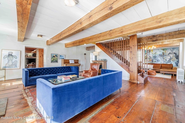 living area with stairway, beamed ceiling, a fireplace, and hardwood / wood-style floors