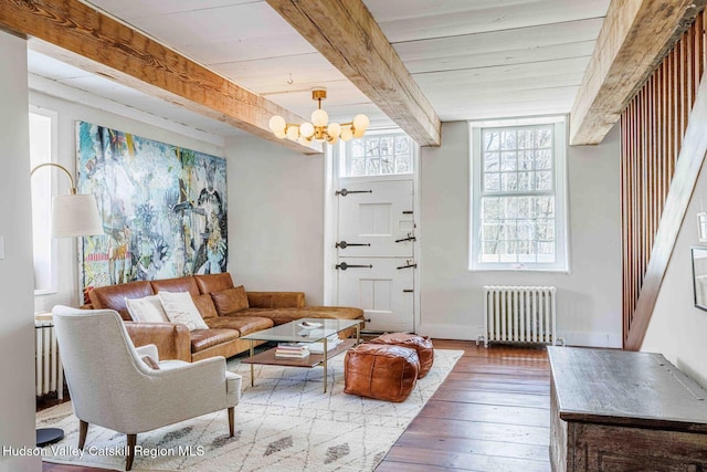 living area with beam ceiling, a notable chandelier, radiator heating unit, wood-type flooring, and baseboards