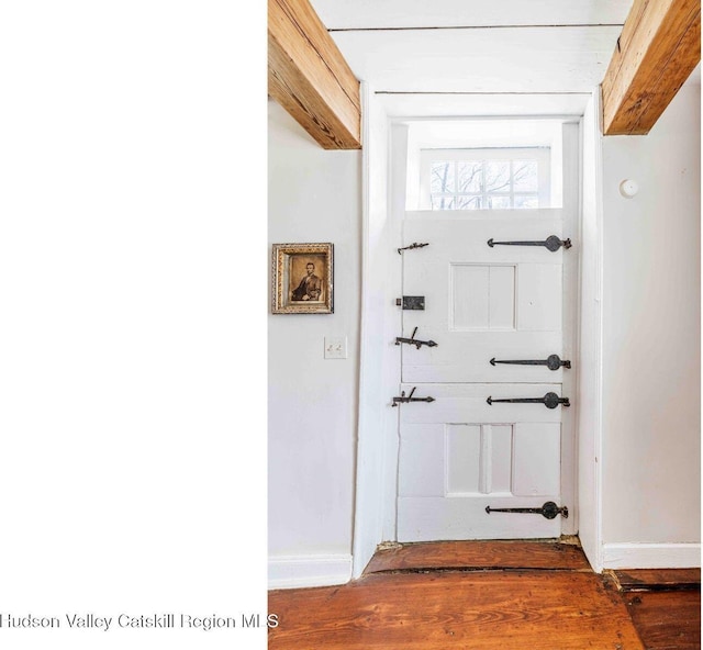 doorway to outside featuring wood finished floors and baseboards