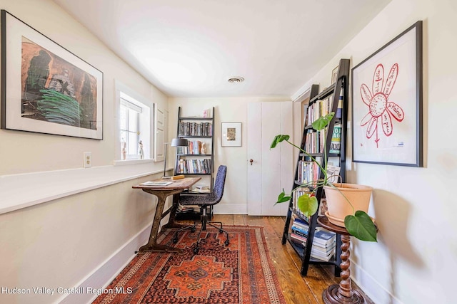 home office with hardwood / wood-style floors, baseboards, and visible vents