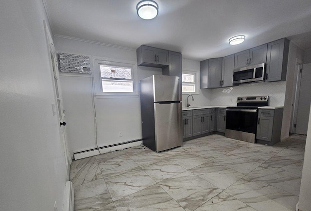 kitchen featuring marble finish floor, gray cabinets, a sink, appliances with stainless steel finishes, and baseboard heating