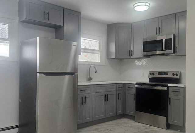 kitchen featuring a sink, gray cabinets, and stainless steel appliances