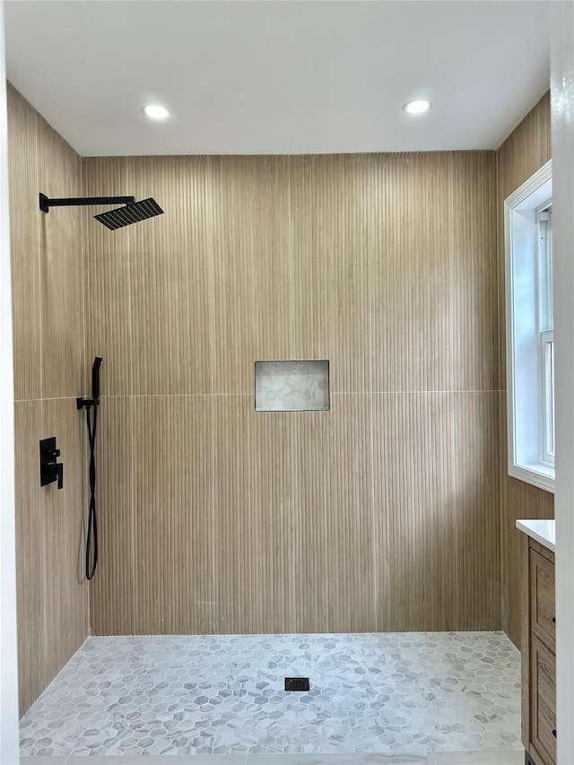 full bathroom featuring recessed lighting, a tile shower, and vanity