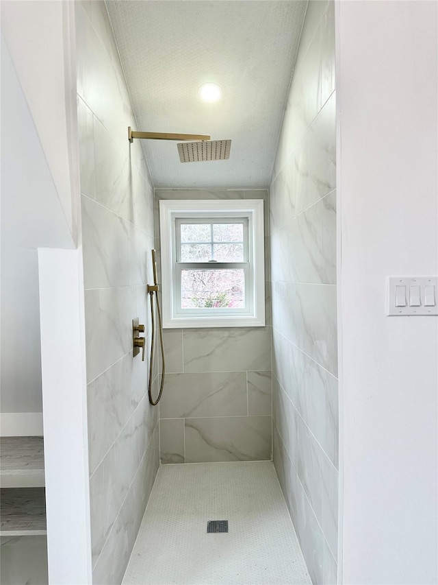 full bath featuring a tile shower and visible vents