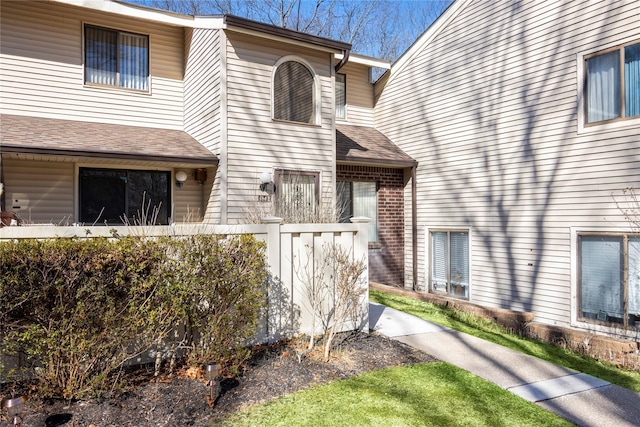 property entrance with brick siding and roof with shingles