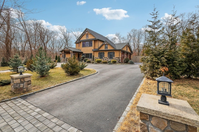 view of front of home featuring stone siding and driveway