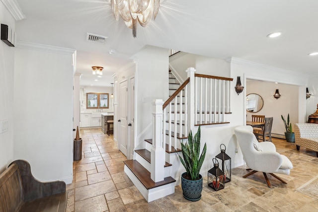 staircase with visible vents, stone tile floors, ornamental molding, and an inviting chandelier