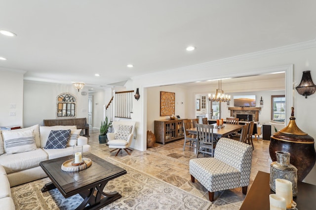 living room featuring stone tile floors, a notable chandelier, stairs, and crown molding