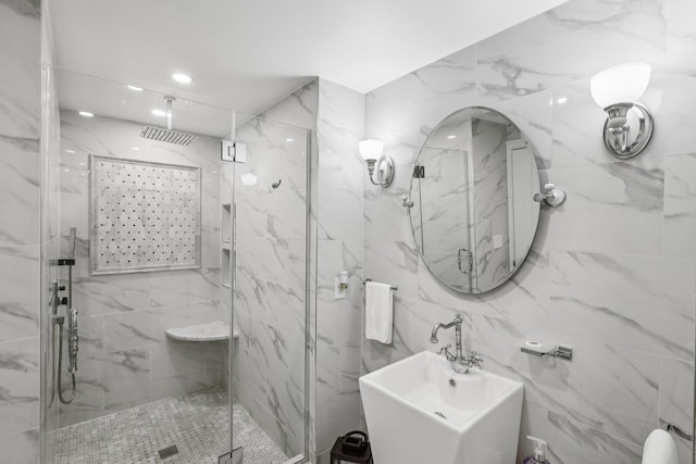 full bathroom featuring a sink and a marble finish shower