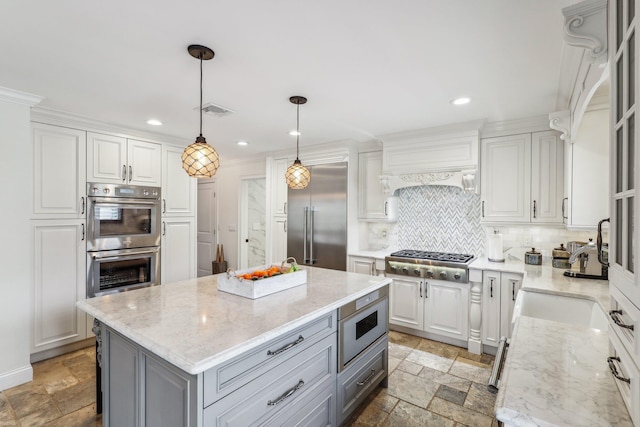 kitchen with tasteful backsplash, visible vents, stone tile floors, gray cabinets, and stainless steel appliances