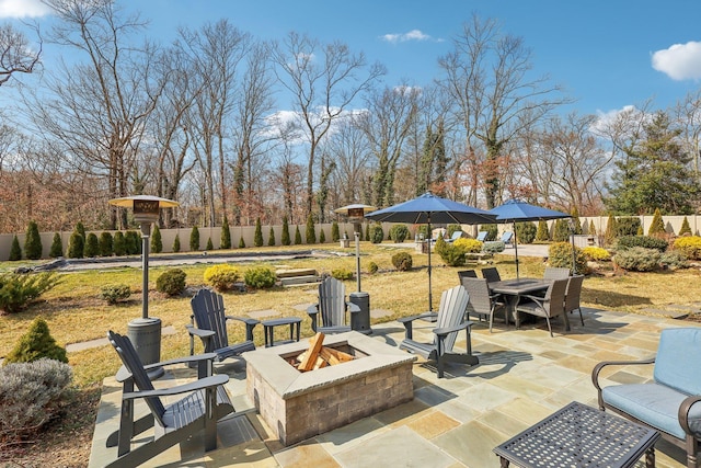 view of patio / terrace with outdoor dining space, a fire pit, and fence