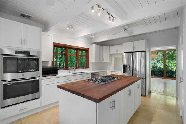 25 Moseman Ave, Katonah, NY 10536 - kitchen featuring butcher block counters, stainless steel appliances, a sink, healthy amount of natural light, and beamed ceiling
