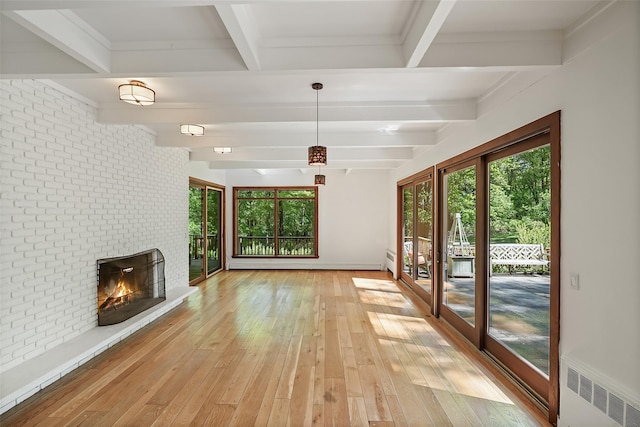 25 Moseman Ave, Katonah, NY 10536 - unfurnished living room featuring beam ceiling, plenty of natural light, light wood-style flooring, a brick fireplace, and radiator