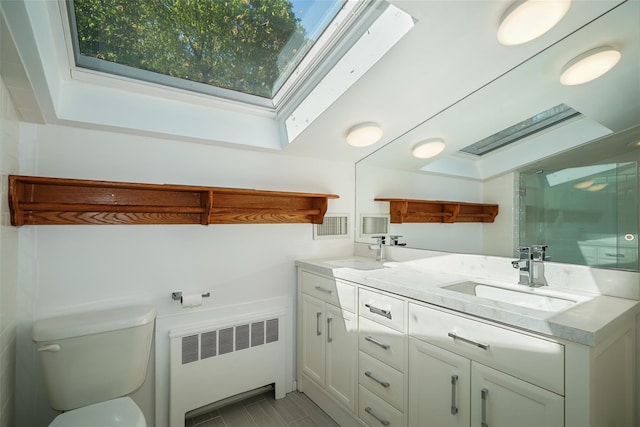 25 Moseman Ave, Katonah, NY 10536 - bathroom featuring radiator heating unit, a stall shower, a skylight, toilet, and double vanity
