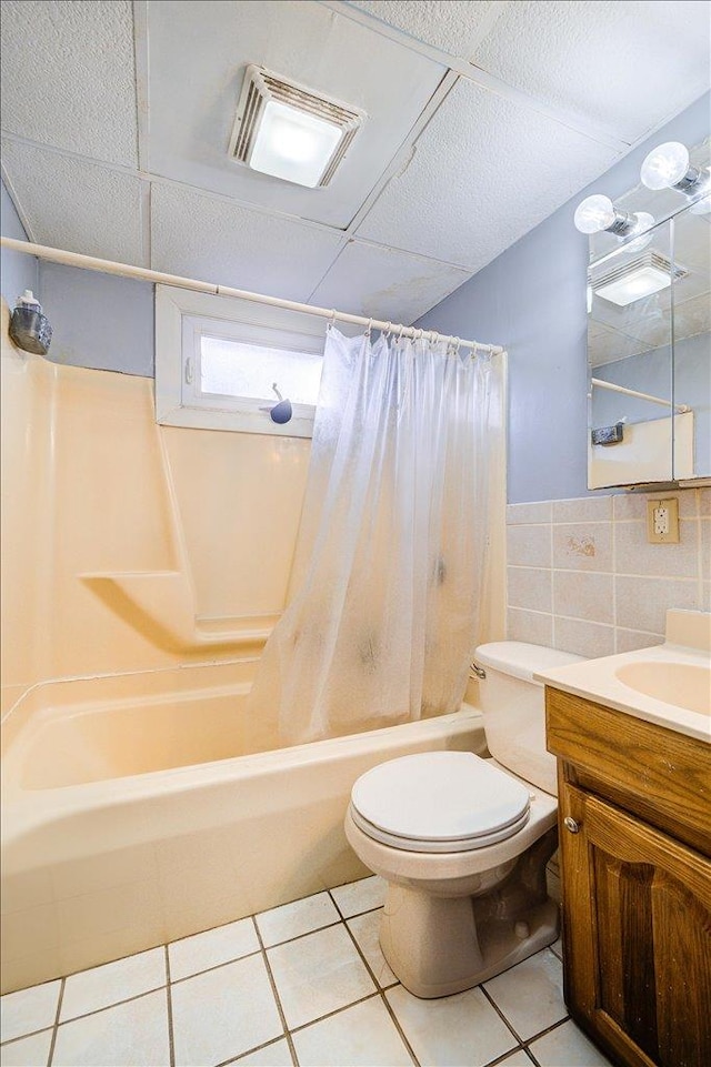 full bathroom with tile patterned flooring, visible vents, toilet, shower / bath combination with curtain, and tile walls