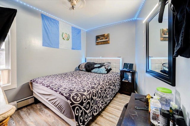 bedroom featuring a baseboard radiator and wood finished floors