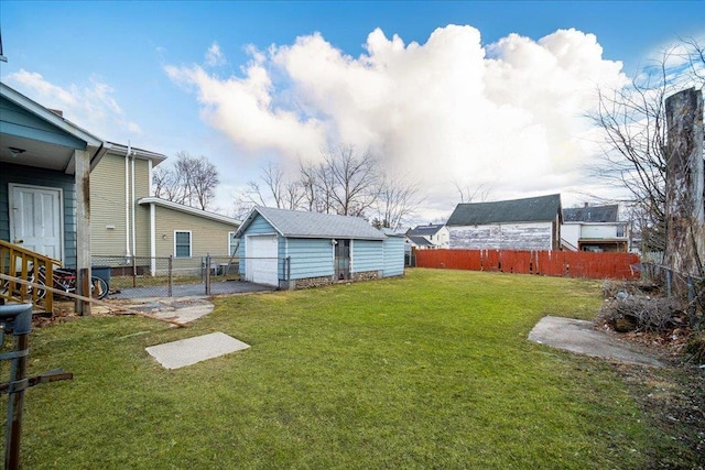 view of yard featuring an outbuilding, a gate, a garage, and fence