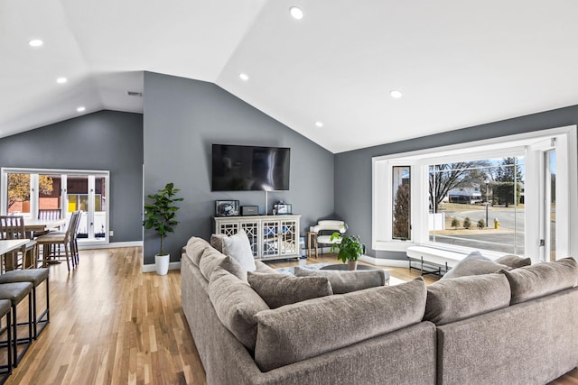 living room with a wealth of natural light, baseboards, recessed lighting, and light wood finished floors