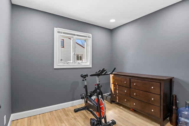 exercise room with baseboards and wood finished floors