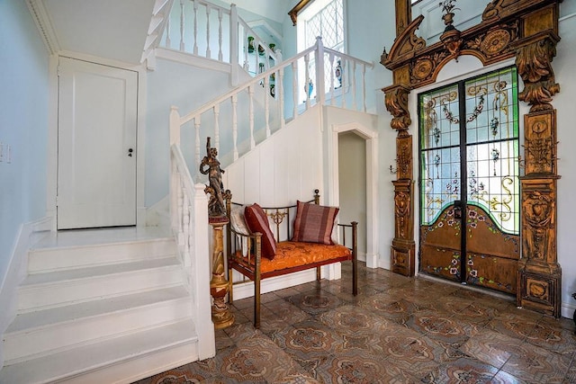 entrance foyer with stairway and a high ceiling