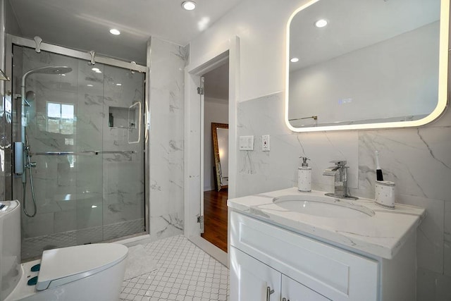 bathroom with toilet, a marble finish shower, tile walls, and vanity