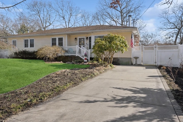 view of front of house featuring driveway, fence, a front lawn, and a gate