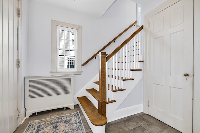 stairs with baseboards and heating unit