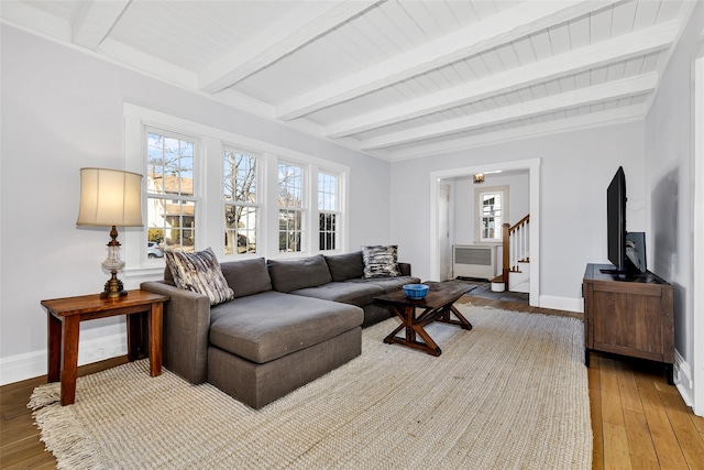 living area featuring light wood-style flooring, stairs, and baseboards