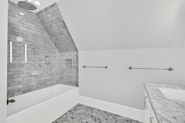 bathroom with bathtub / shower combination, lofted ceiling, vanity, and baseboards