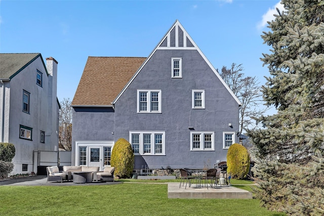 back of property featuring a patio area, a lawn, outdoor lounge area, and stucco siding